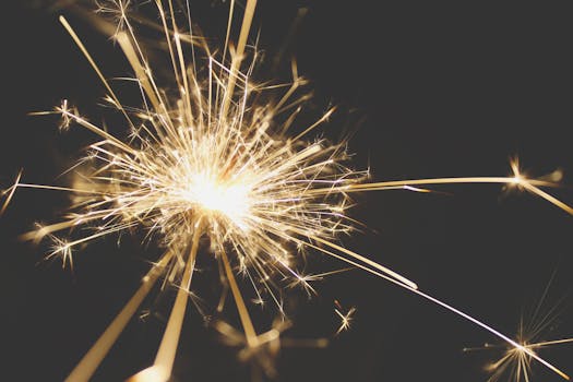 Close-up of a dazzling sparkler bursting with light against a dark background, perfect for celebrations.